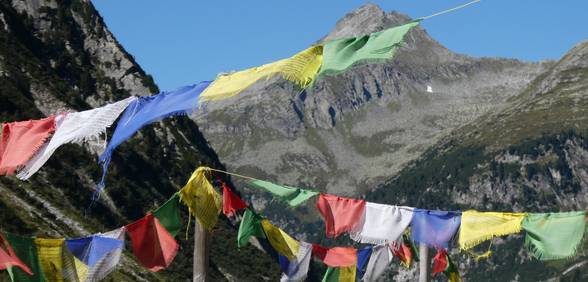 Tibetische Gebetsfahnen mit Speichersee im Hintergrund